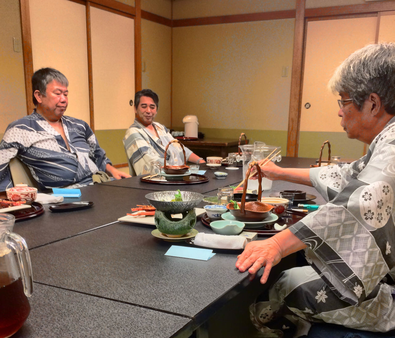 「おい三田の、最近浜松町からのシノギが少ないのぉ」厳しく叱責するT組長(写真右)。「大門のと板橋のが、そろそろモウロクしとるようで。今度喝入れときま」他責にする三田のN組長(写真左)。写真中は「そろそろ俺の時代や、ホホホッ」と次世代を狙う浜松町駅前組のN組長